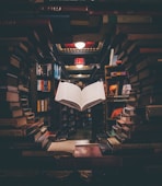 view of floating open book from stacked books in library