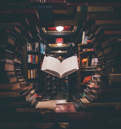 view of floating open book from stacked books in library