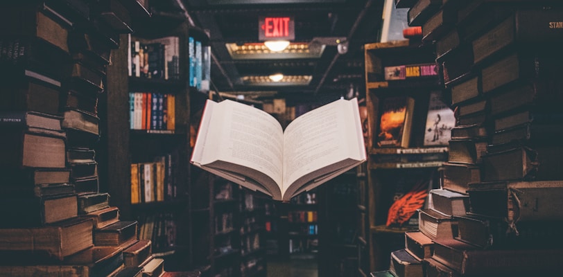 view of floating open book from stacked books in library