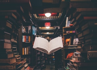 view of floating open book from stacked books in library