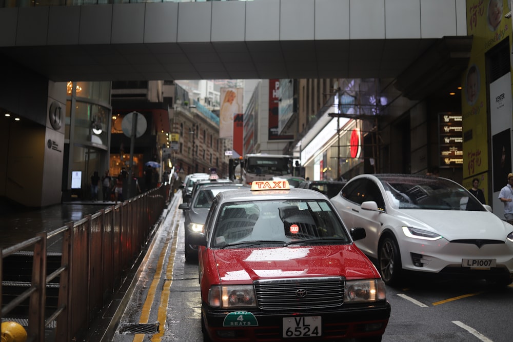 cars travelling on road between buildings at daytime