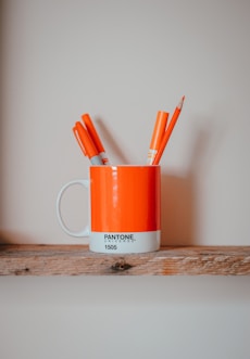 markers in mug on brown surface