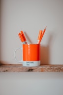 markers in mug on brown surface