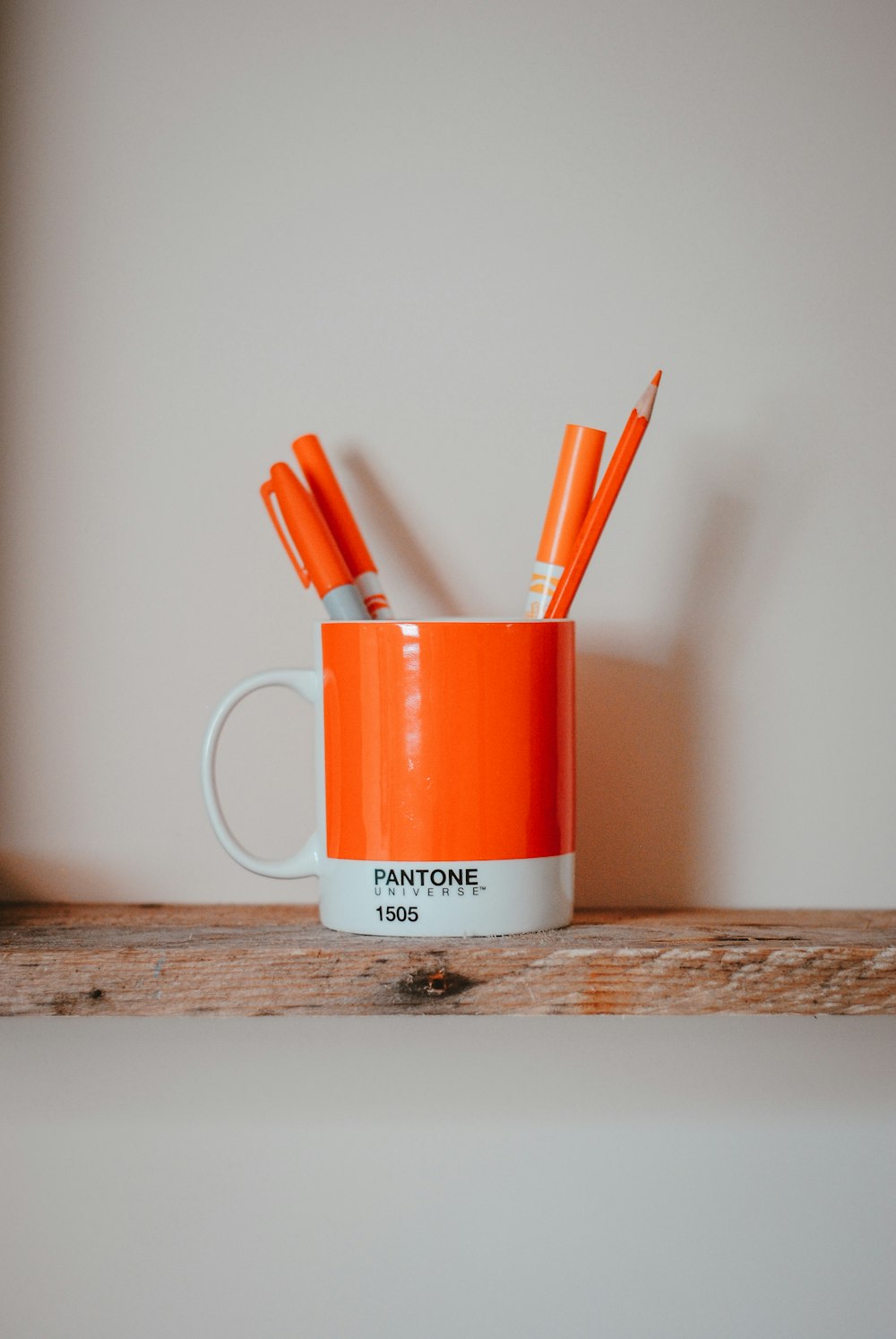 markers in mug on brown surface