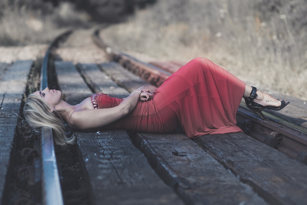 woman lying on train rail