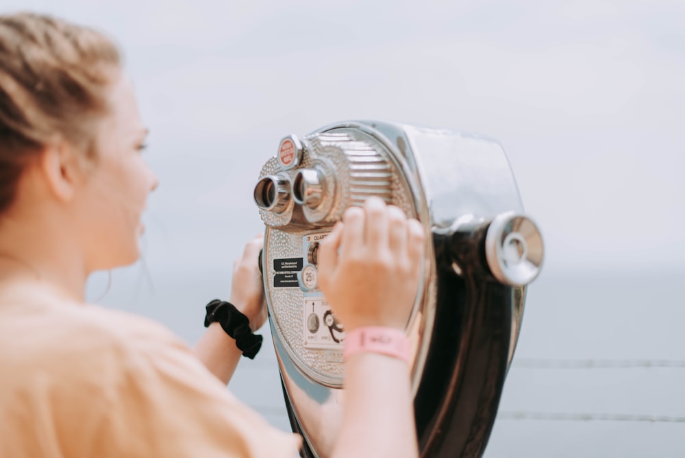 woman holding gray building telescope