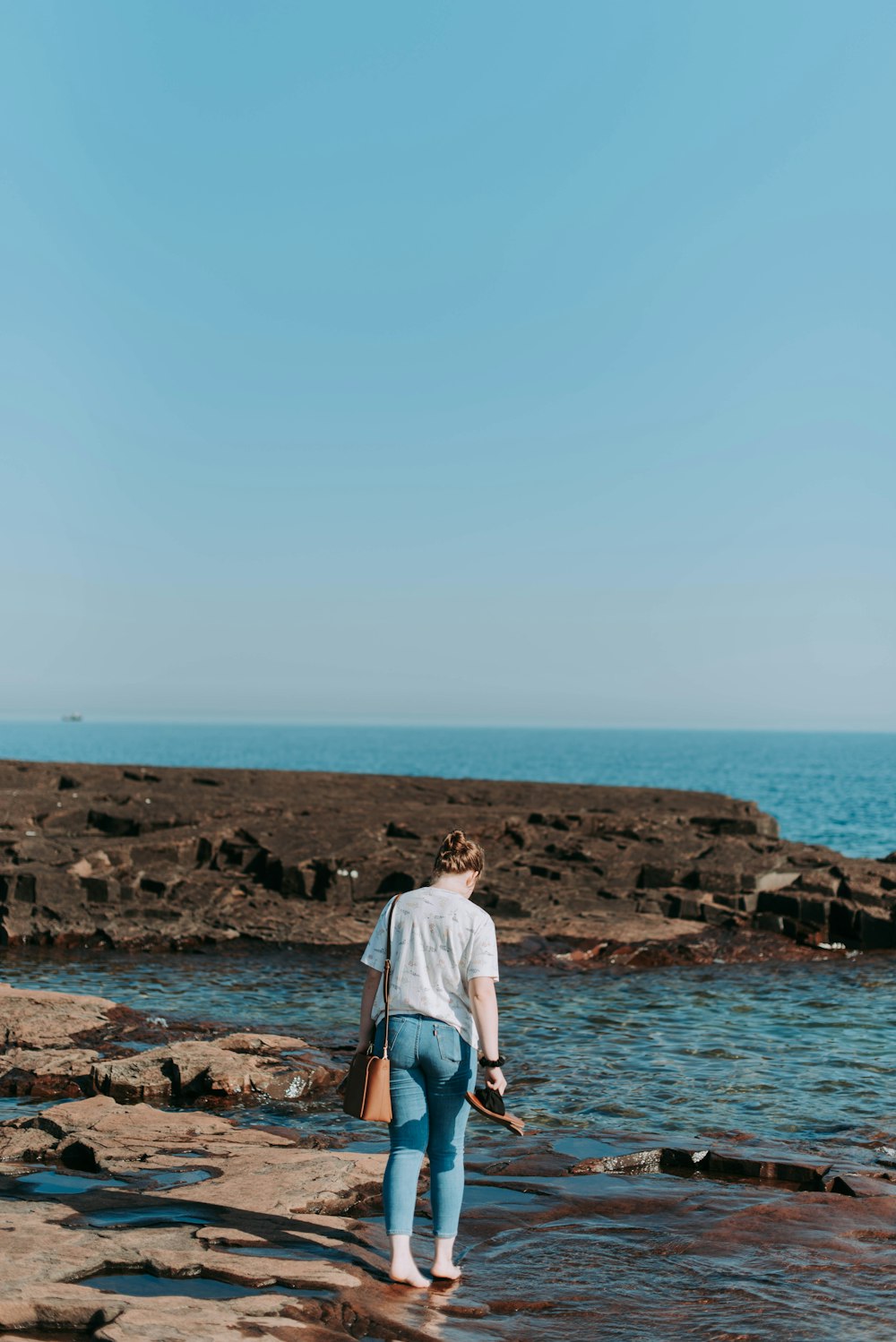 woman walking on shore by the sea