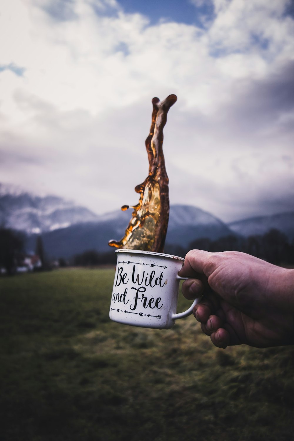 person holding white mug