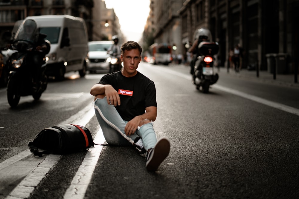 man sitting on concrete roadway