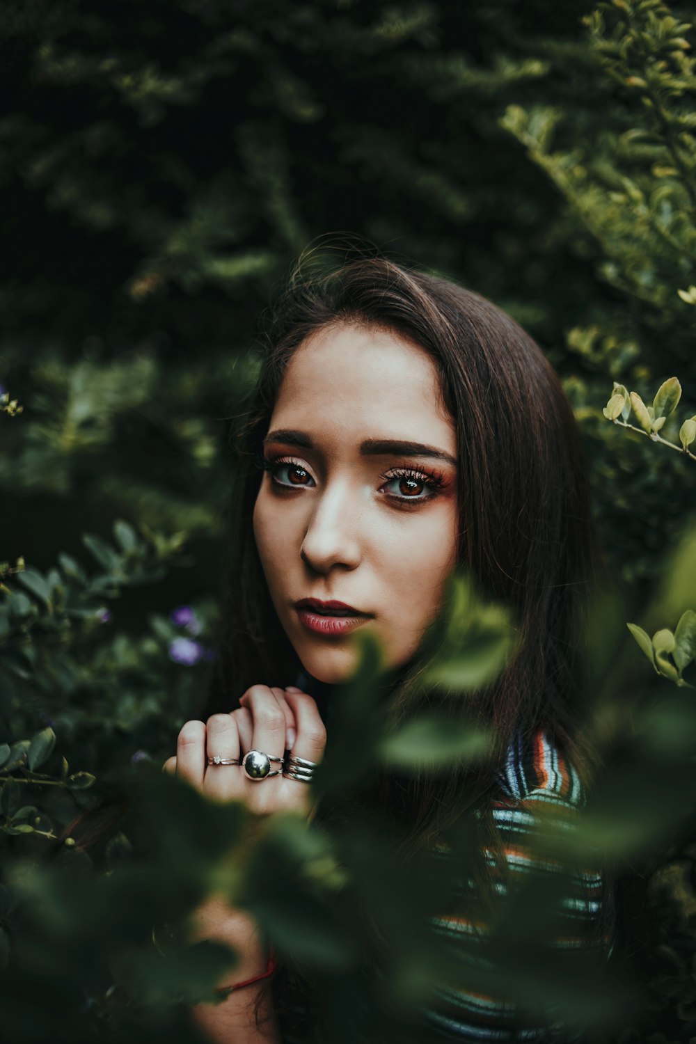 selective focus photography of woman surrounded with plants