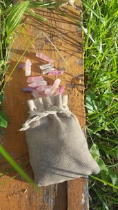 A vibrant display of colorful tumbled stones spilling from a rustic cloth bag.