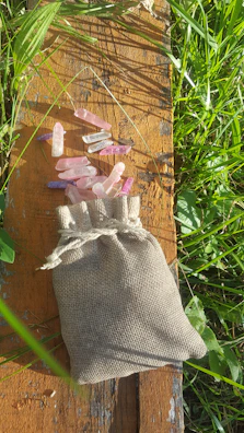 A collection of mixed gemstones gently spilling from a linen pouch.