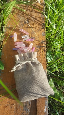 A vibrant display of colorful tumbled stones spilling from a rustic cloth bag.