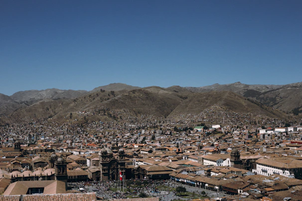 A panoramic view of Cusco city blending colonial architecture with the surrounding mountains.