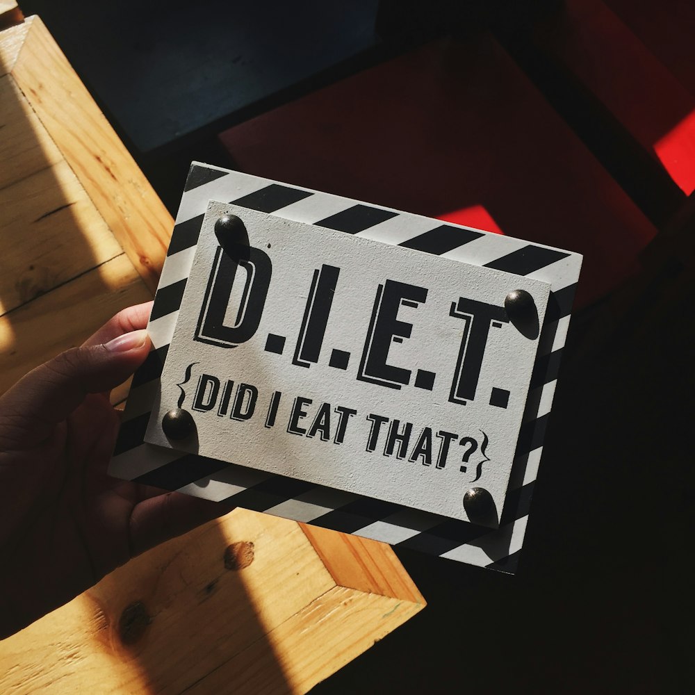 person holding DIET quote board