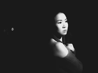 An atmospheric shot of Pauline Pastel framed by shadows, highlighting the contrast and mood of the black-and-white series.