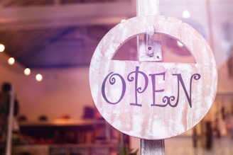 selective focus photography of store open sign hanging on door
