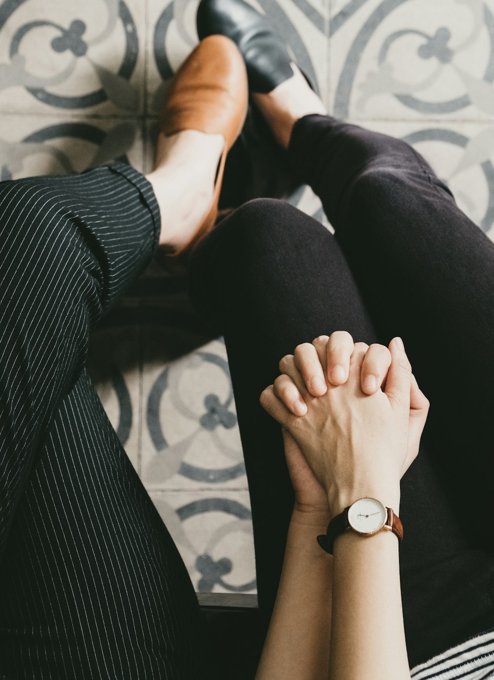 man and woman holding hands while sitting on chair