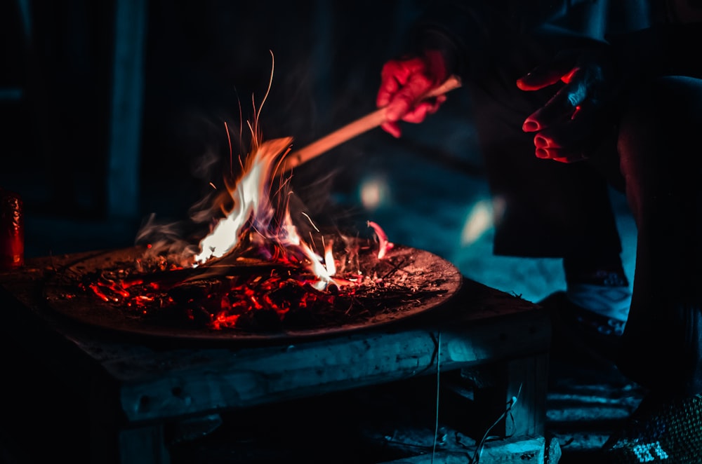 man burning stick during nighttime