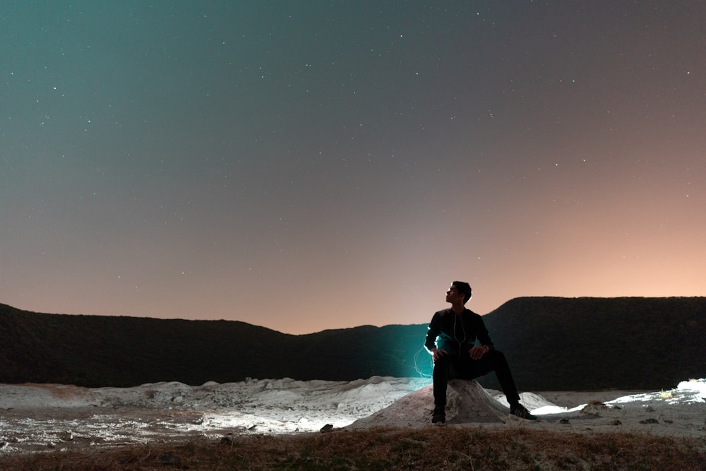 man sitting on rock