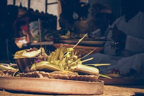 A close-up of traditional offerings arranged beautifully on a white cloth with gold accents.