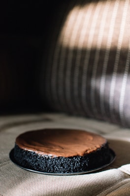 Artisanal cake with golden details and smooth icing, captured in warm natural light.