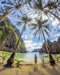 Smiling woman enjoying a tropical beach in Langkawi with clear blue skies.