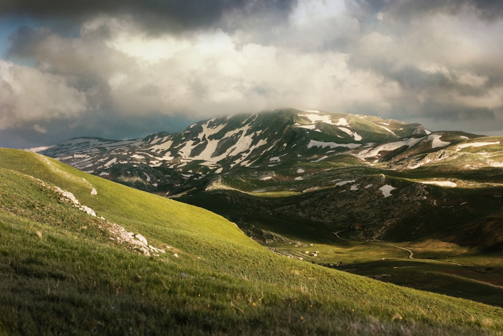 mountain rage view under cloudy sky during daytime