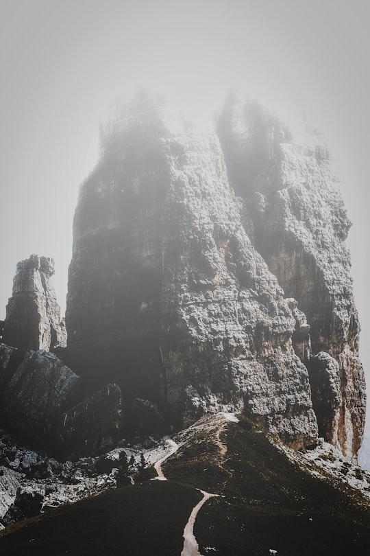 grey rock formation under cloudy skies in Cinque Torri Italy