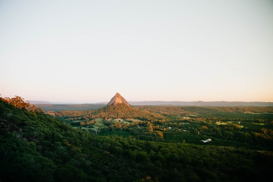 brown pyramid on green grass field during daytime in Glass House Mountains National Park Australia