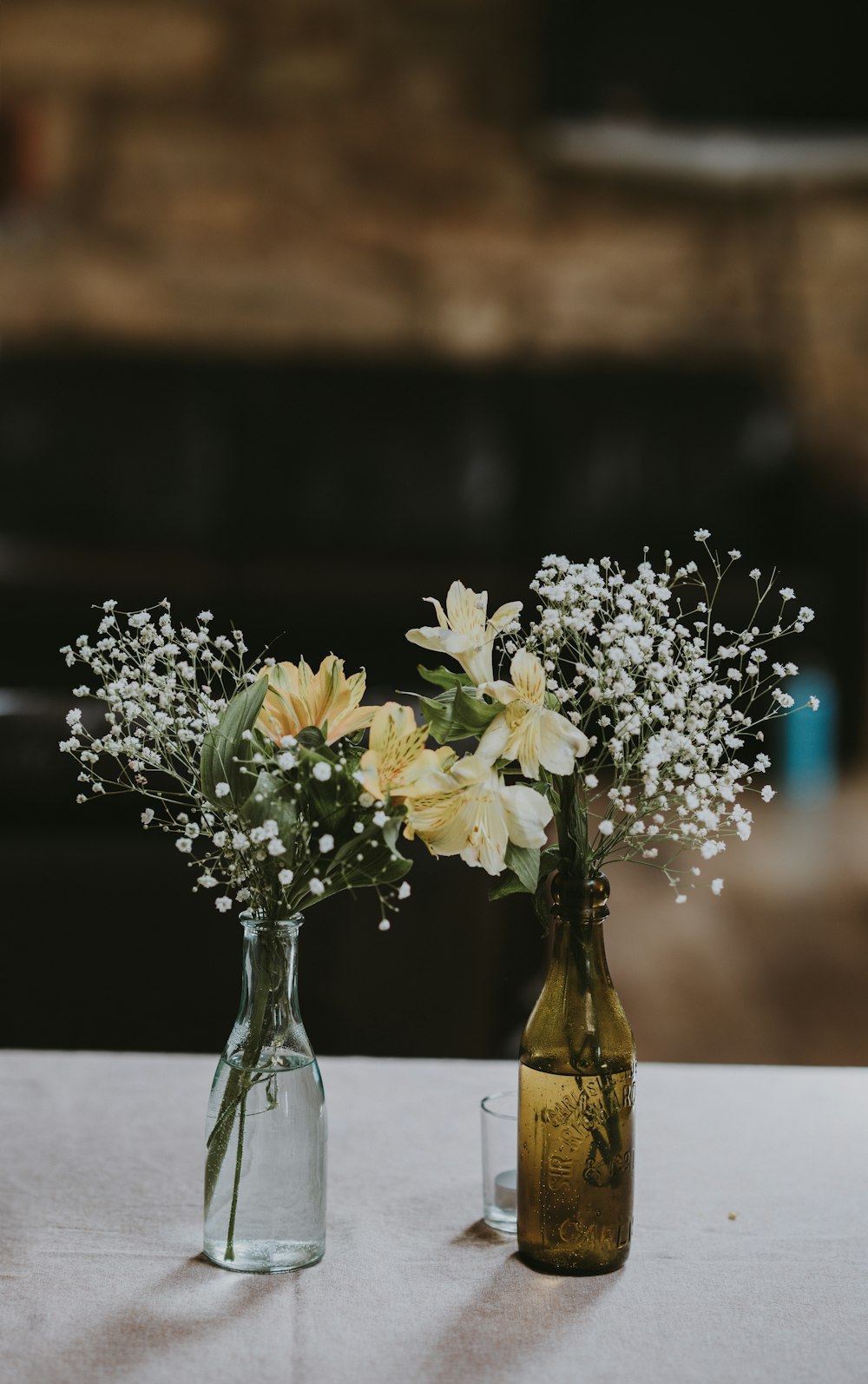 fleurs blanches et jaunes sur des bouteilles en verre transparent