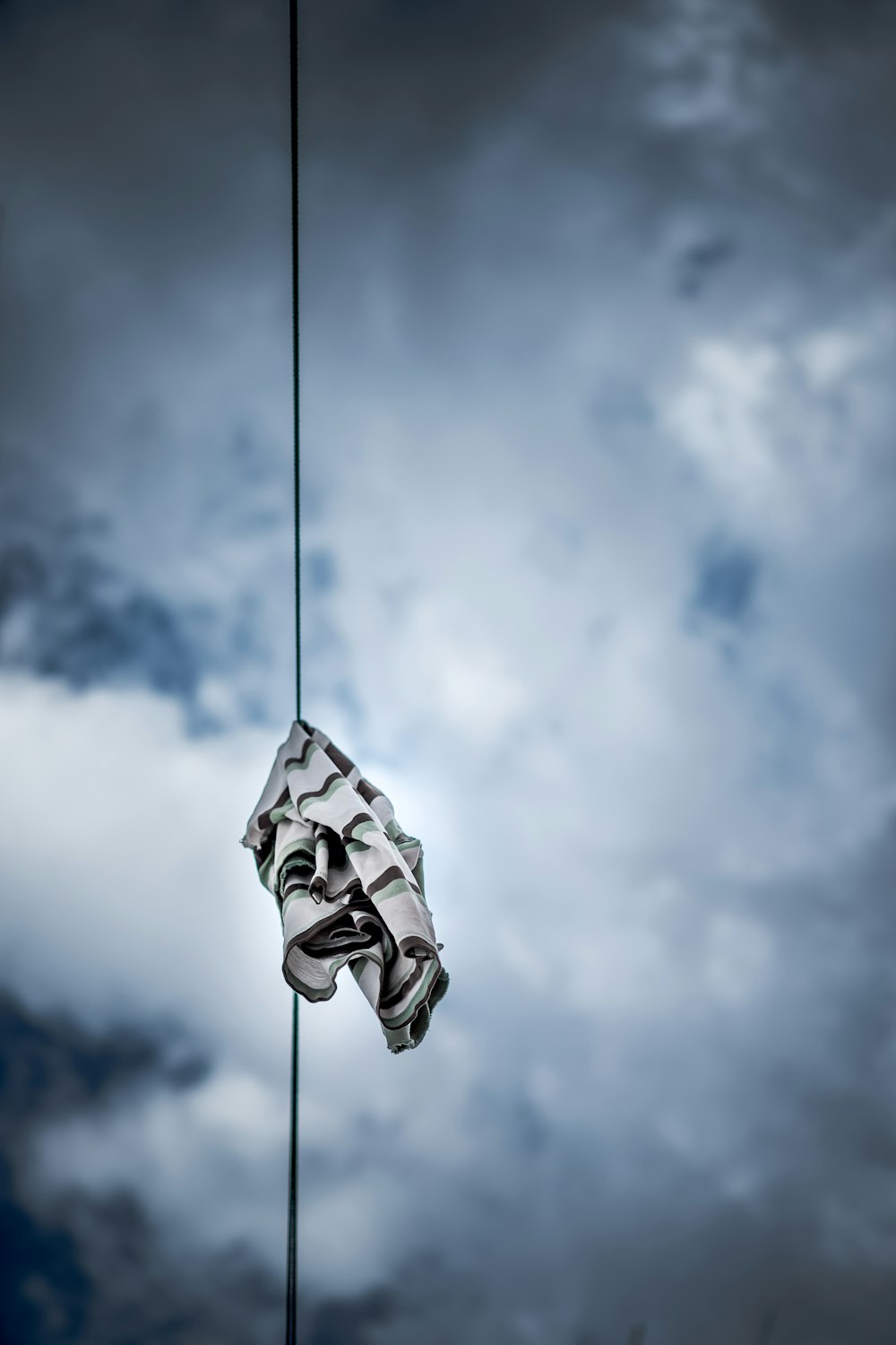 black and gray striped textile hanged from black cable during cloudy day