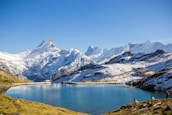A serene mountain landscape with hikers enjoying the panoramic views under a clear blue sky.