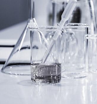 three clear beakers placed on tabletop