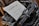An old-fashioned typewriter holds a sheet of paper with printed text. The paper includes the word 'PORTO' prominently and appears to be some form of advertisement or notice, with additional information about hours or scheduling.