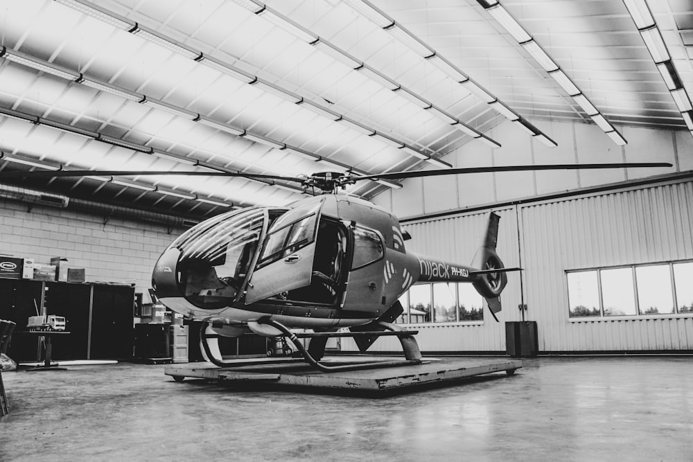 grayscale photography of helicopter inside shed