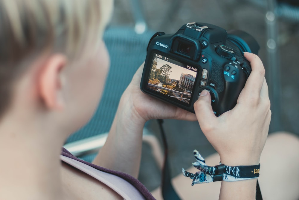 person using black Canon DSLR camera