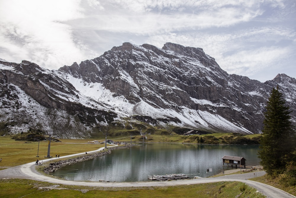 mountain range near lake under the cloudy skies