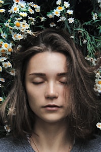 woman closing her eyes on white flower