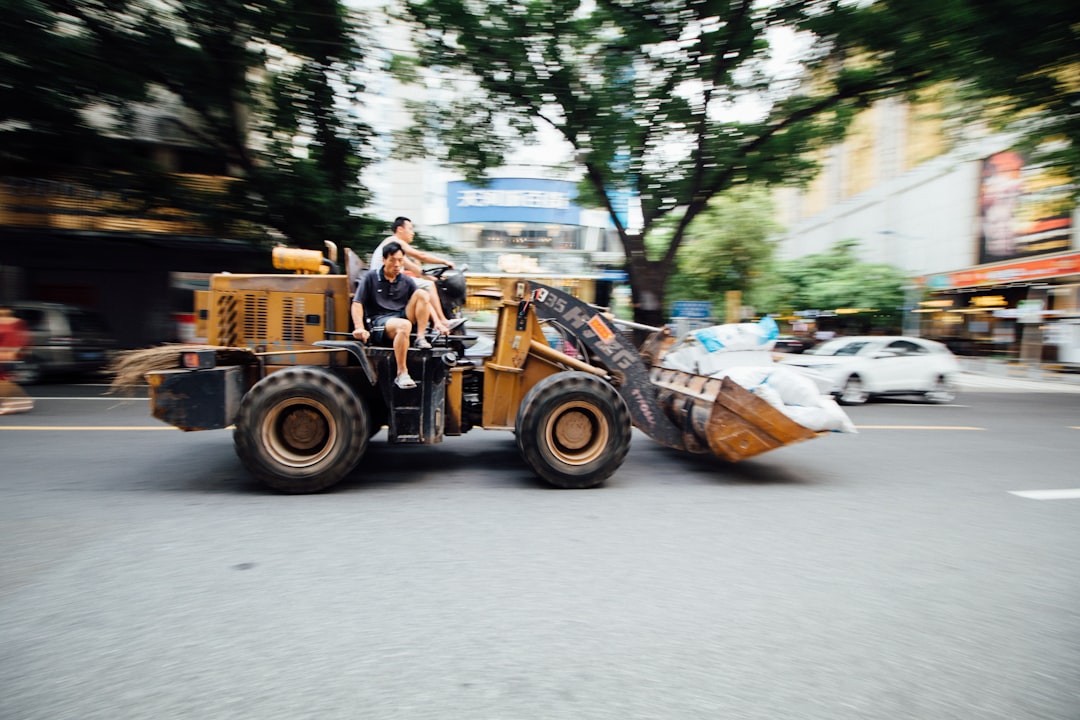 yellow and black front loader on road during daytime