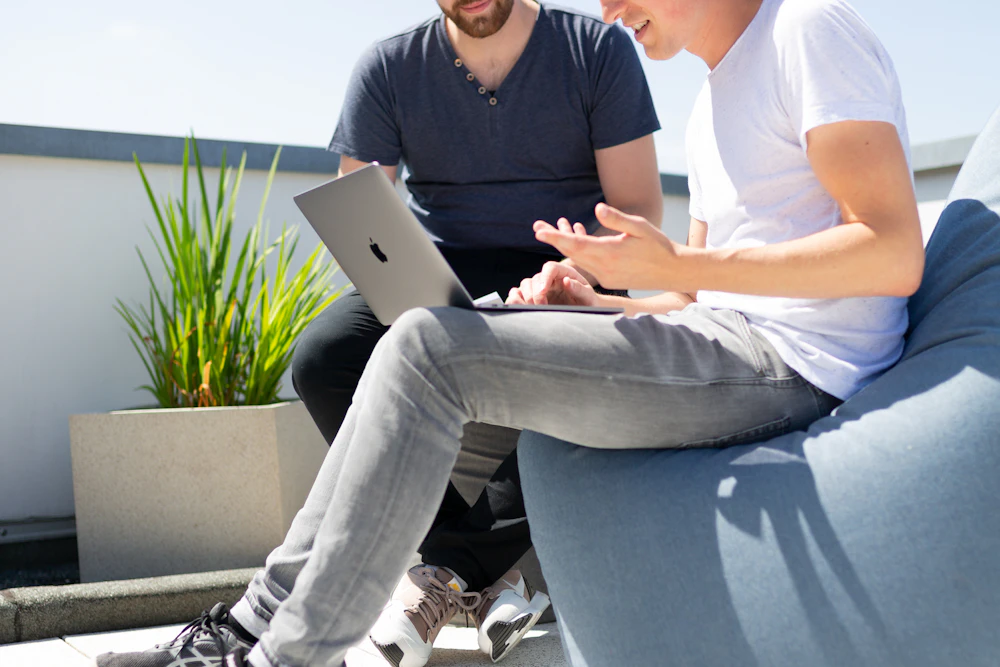 Zwei Kollegen prüfen gemeinsam Daten am Laptop
