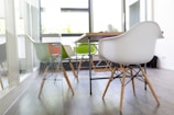 rectangular brown wooden table beside chairs in white wall paint room