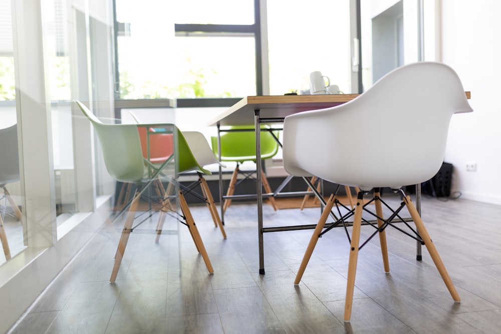 rectangular brown wooden table beside chairs in white wall paint room