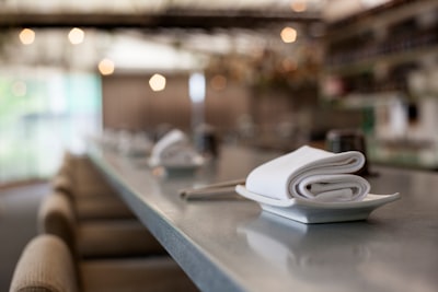 selective focus photography of white textile on platter napkin teams background