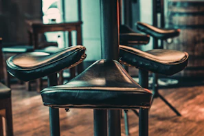 Close-up of a modern metal bar stool with a sleek black finish and footrest.