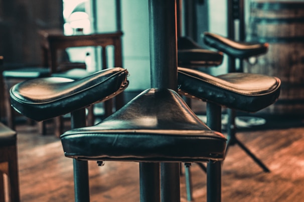 A modern PU leather bar stool with a shiny metal base in a kitchen setting.