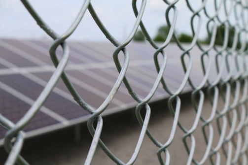 Solar fencing panels securing a commercial property at dusk.