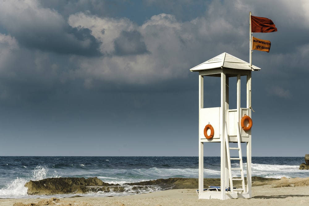 white wooden lifeguard house near seashore