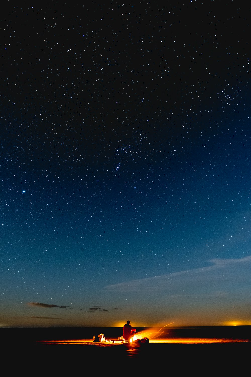 Person, die unter dem Sternenhimmel sitzt