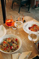 four filled wine glasses and foods on table